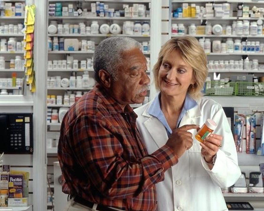 Assurance pharmacist reviewing medication with a patient